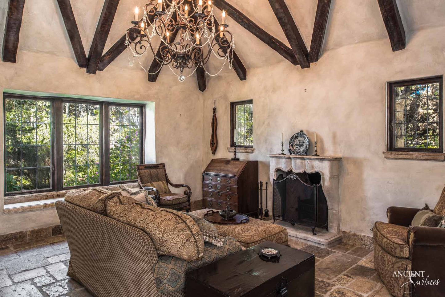 Our reclaimed limestone mantle offers a sanctuary of vintage elegance, merging historical richness with the comfort of an old-world lounge. The natural patina of the limestone complements the room's aged timber beams and ornate chandelier, infusing a sense of time-honored luxury. Ideal for creating a focal point in your space that exudes a deep, historical ambiance, perfect for storytelling and relaxation.