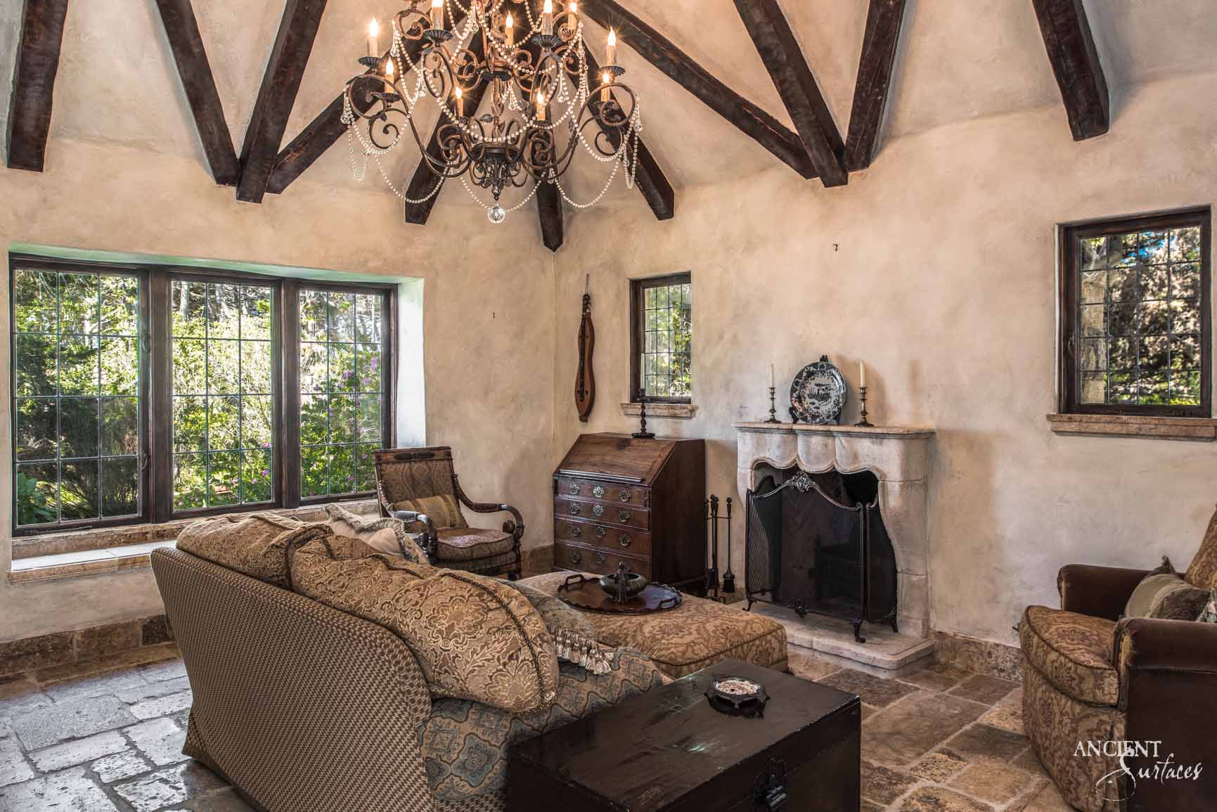 Our reclaimed limestone mantle offers a sanctuary of vintage elegance, merging historical richness with the comfort of an old-world lounge. The natural patina of the limestone complements the room's aged timber beams and ornate chandelier, infusing a sense of time-honored luxury. Ideal for creating a focal point in your space that exudes a deep, historical ambiance, perfect for storytelling and relaxation.